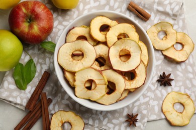 Delicious apple chips, fresh fruits, anise and cinnamon on light grey table, flat lay
