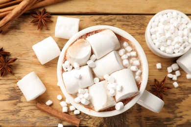 Tasty hot chocolate with marshmallows on wooden table, flat lay