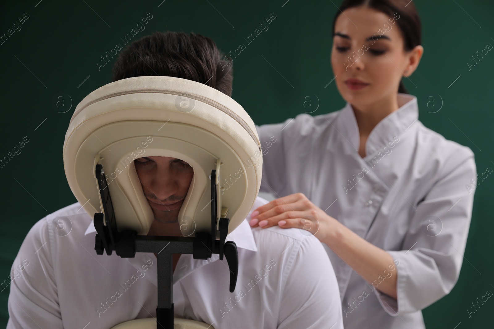 Photo of Man receiving massage in modern chair indoors