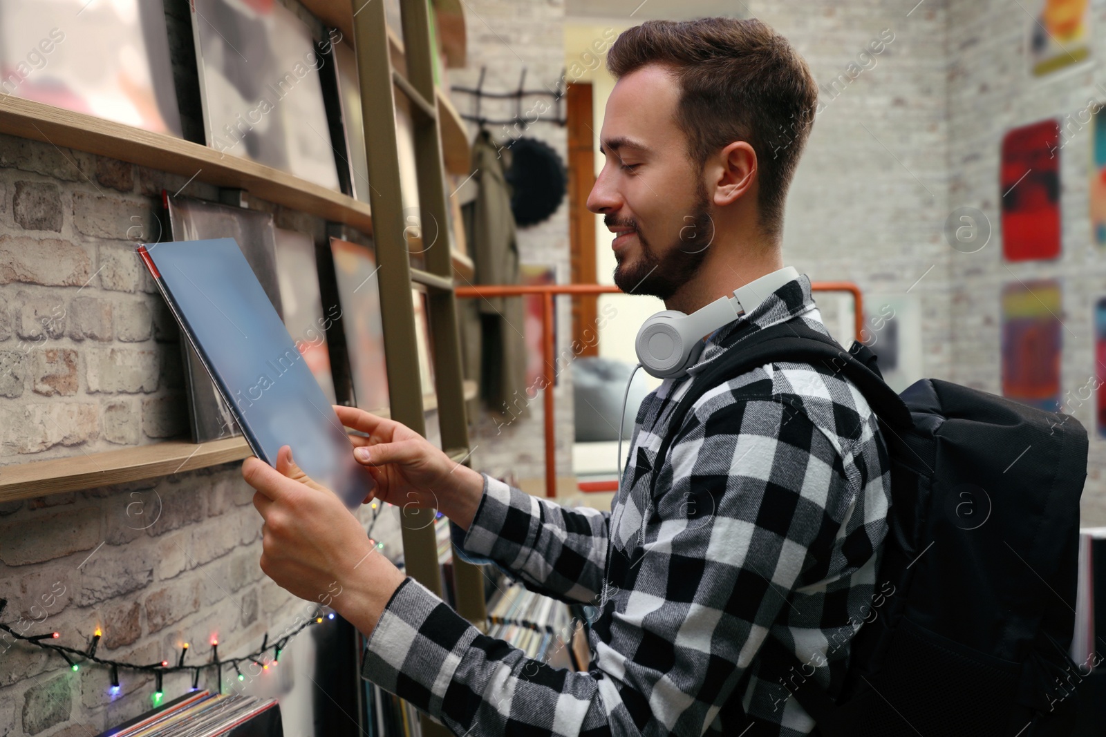 Image of Young man with vinyl record in store