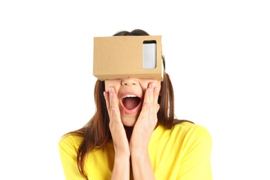 Photo of Young woman using cardboard virtual reality headset, isolated on white