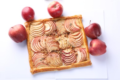 Tasty apple pie with nuts and fresh fruits isolated on white, top view