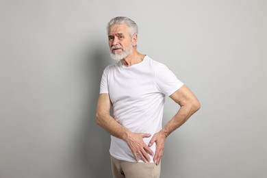 Photo of Arthritis symptoms. Man suffering from hip joint pain on gray background