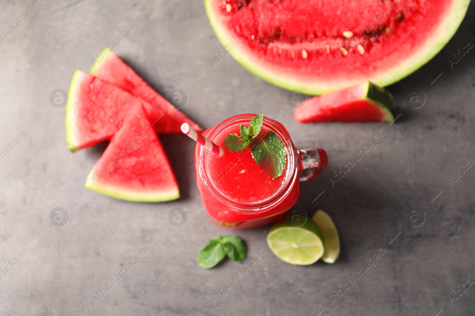 Photo of Summer watermelon drink in mason jar and sliced fruits on table, top view