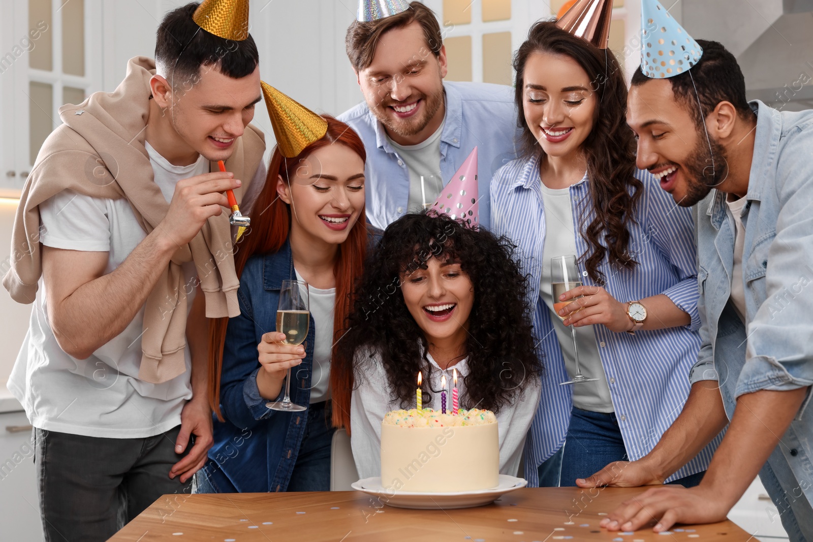 Photo of Happy friends with tasty cake celebrating birthday indoors