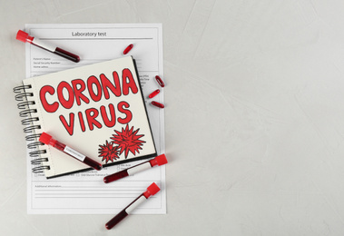 Notepad with words CORONA VIRUS and blood samples on light background, flat lay. Space for text