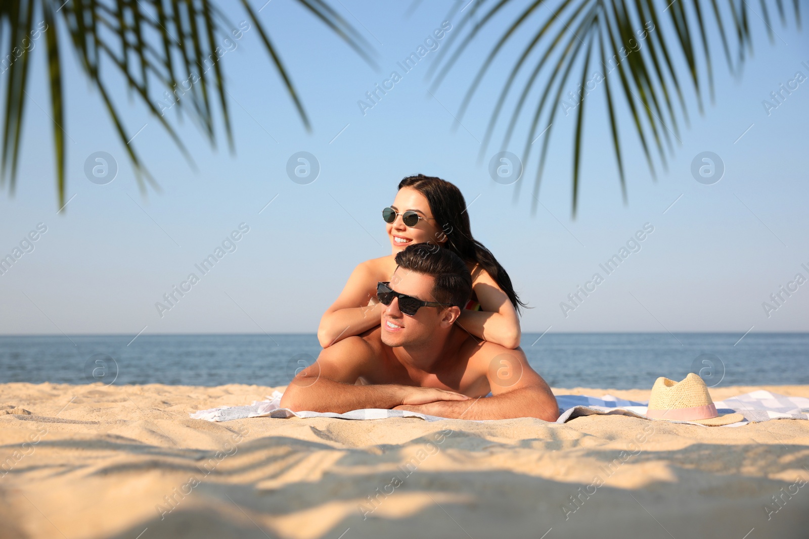 Photo of Happy couple resting on sunny beach at resort