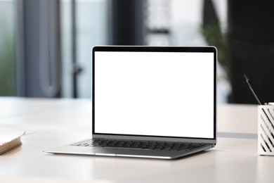Photo of Modern laptop on white desk in office. Mockup for design