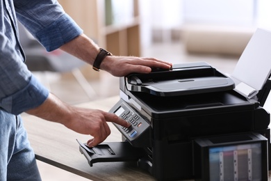 Employee using modern printer in office, closeup