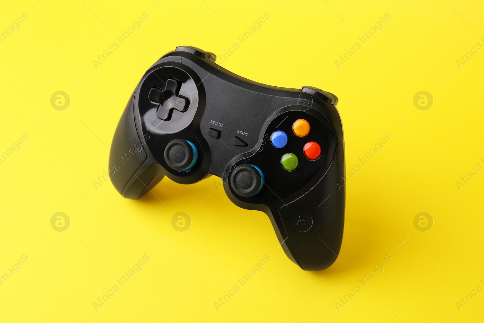 Photo of One wireless game controller on yellow background