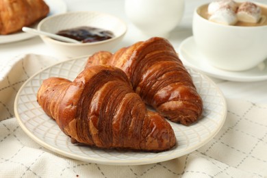 Photo of Plate with tasty croissants on white table, closeup