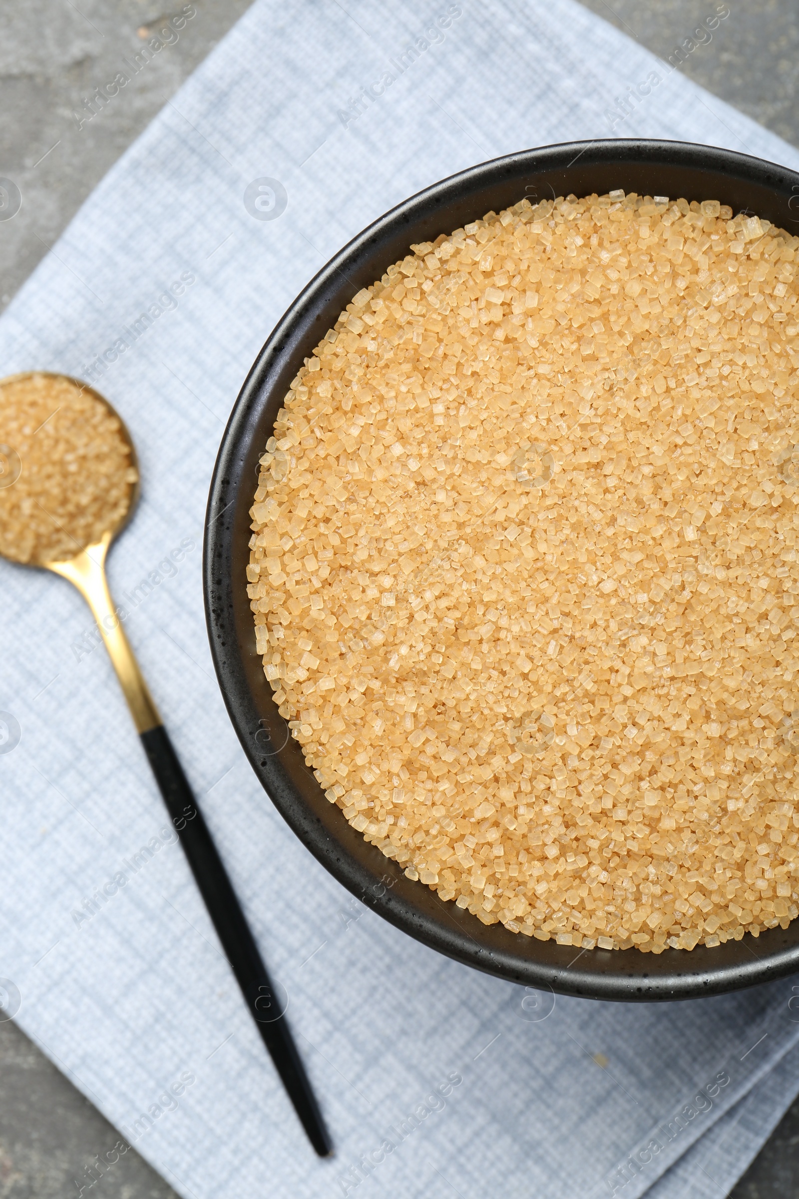 Photo of Brown sugar in bowl and spoon on table, top view