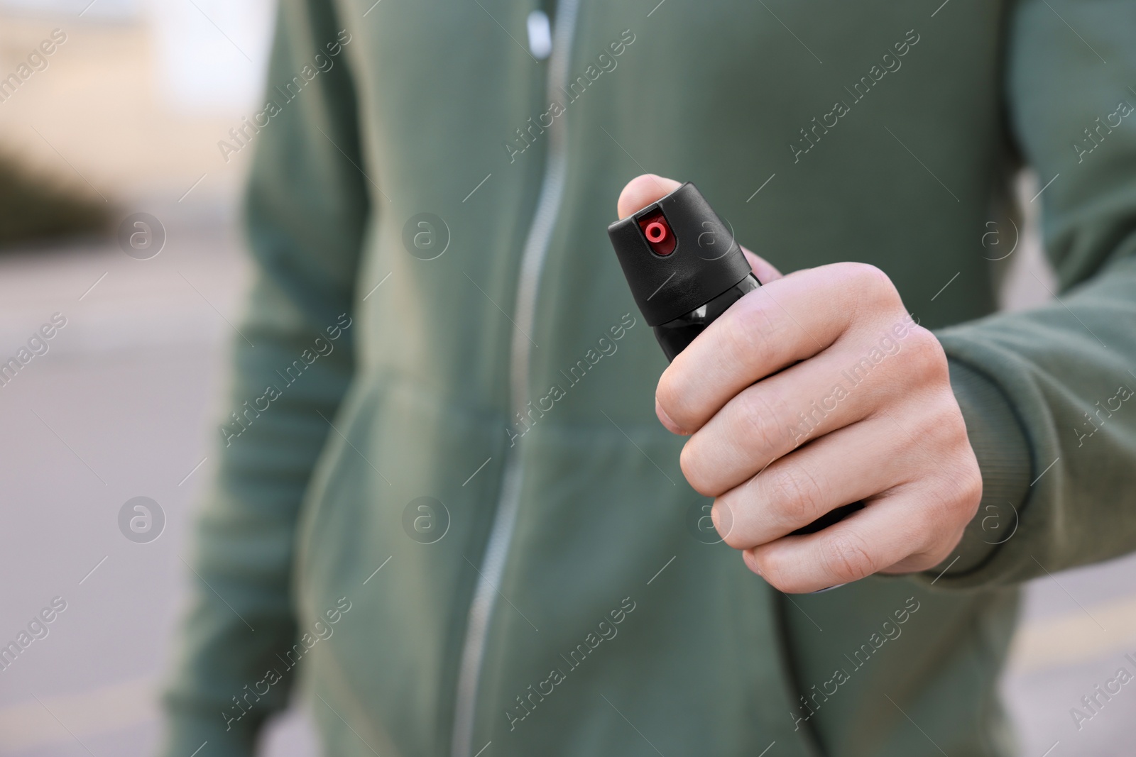 Photo of Man using pepper spray outdoors, closeup. Space for text