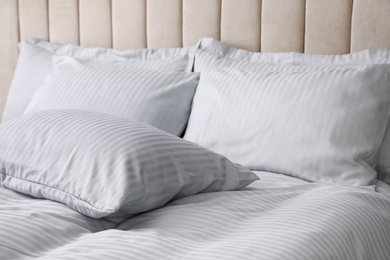 Photo of Comfortable bed with soft blanket and pillows, closeup