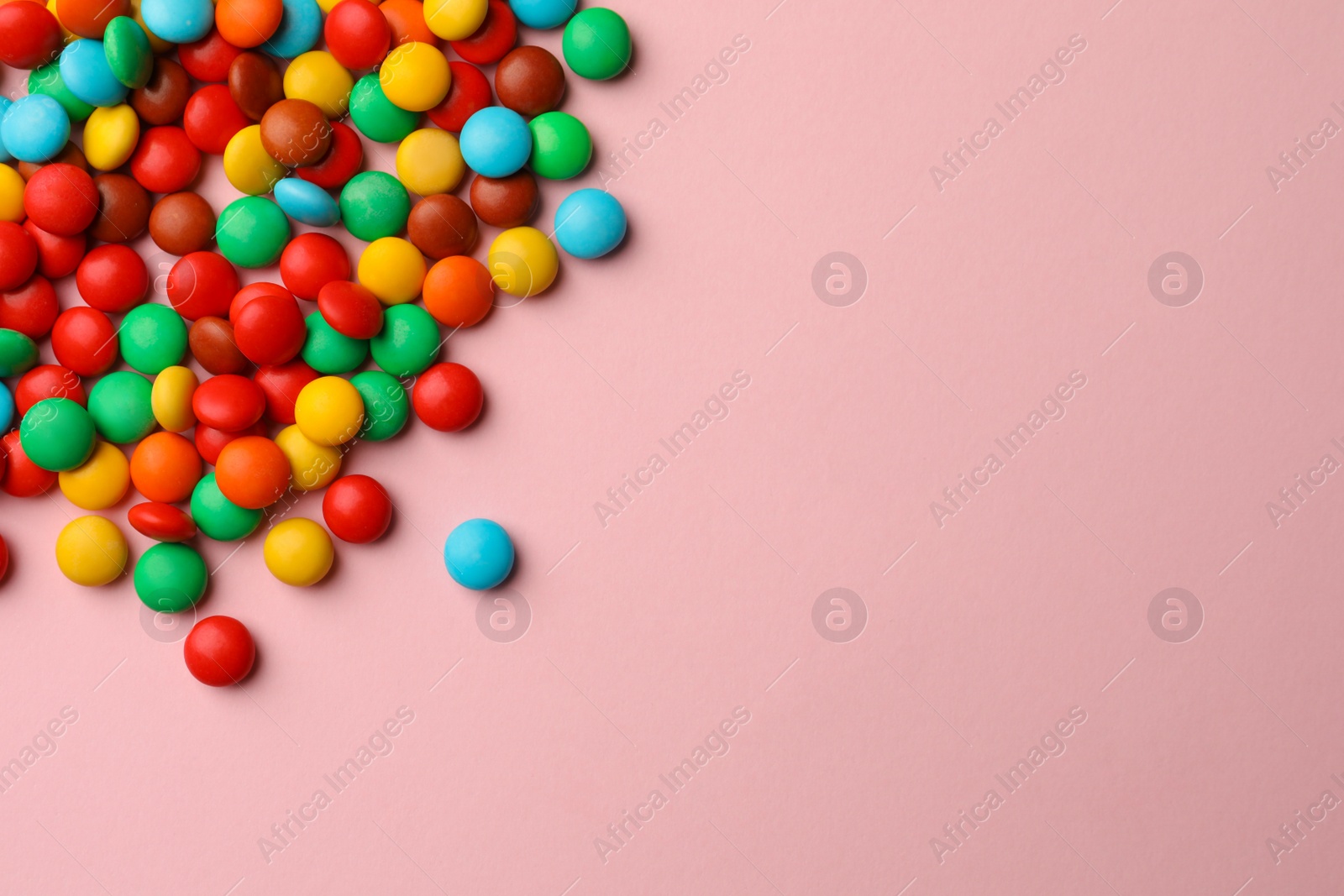 Photo of Tasty colorful candies on pink background, flat lay. Space for text