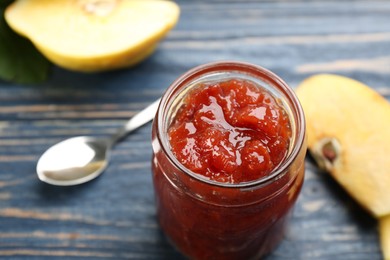 Delicious quince jam and fruits on blue wooden table