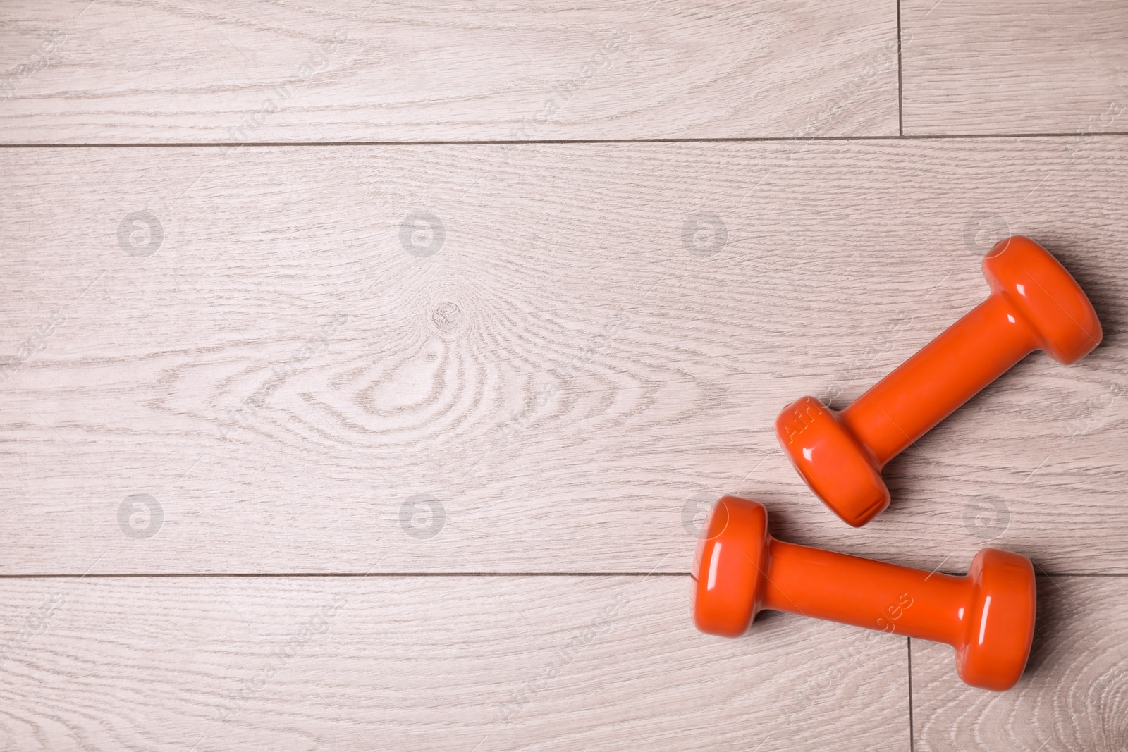 Photo of Vinyl dumbbells and space for text on wooden background, flat lay