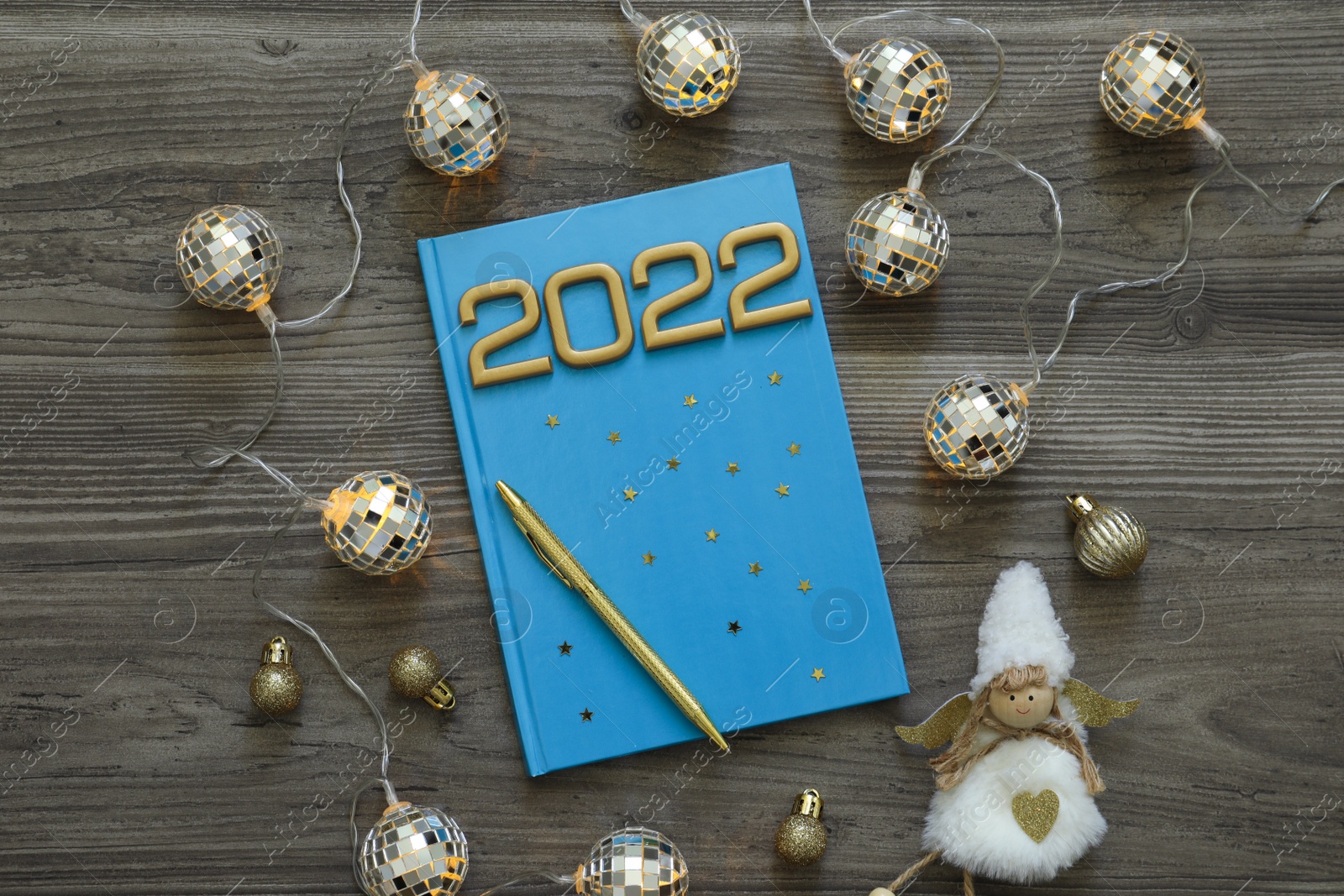 Photo of Planner and Christmas decor on wooden background, flat lay. 2022 New Year aims