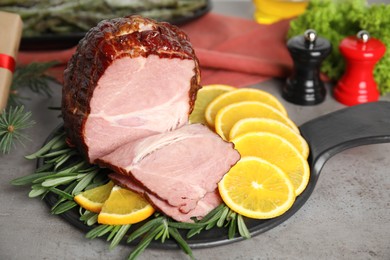 Photo of Delicious ham served with orange and rosemary on grey table. Christmas dinner