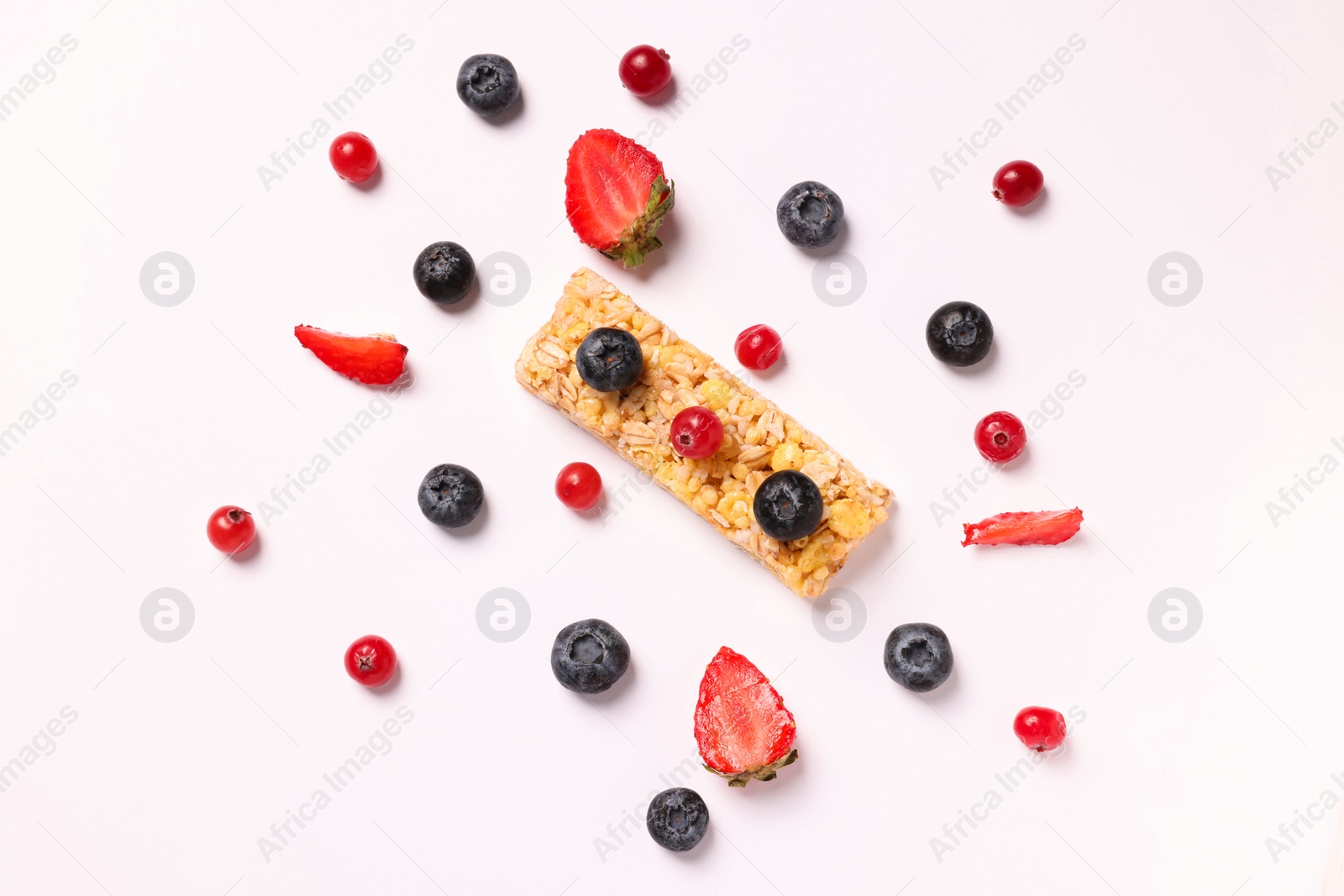 Photo of Tasty granola bar and berries isolated on white, top view