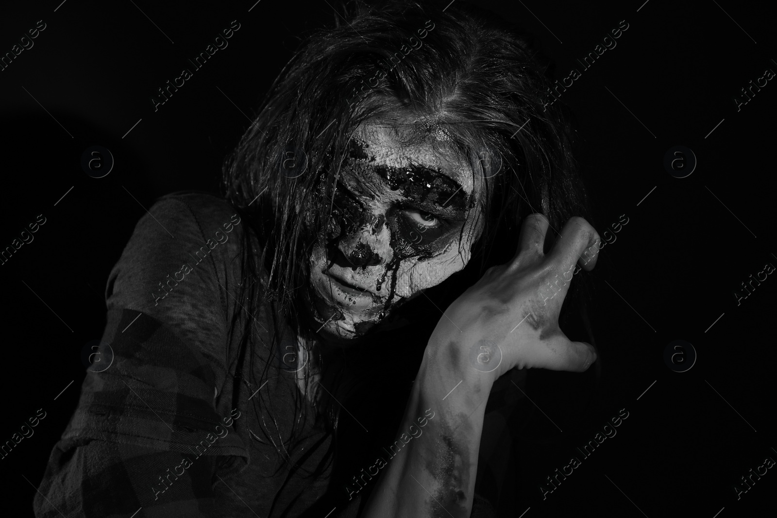 Photo of Scary zombie on dark background, black and white effect. Halloween monster