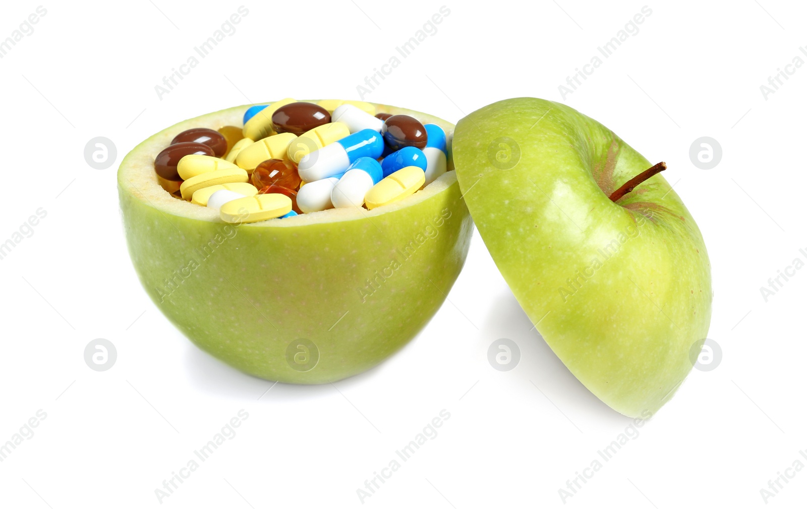 Photo of Cut apple full of weight loss pills on white background