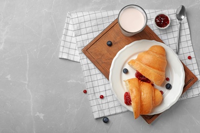 Photo of Tasty croissant with jam served for breakfast on table, top view