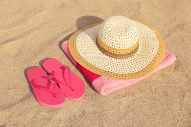 Photo of Beach towel with straw hat and slippers on sand