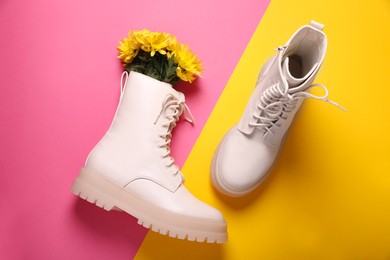 Pair of stylish leather shoes with flowers on color background, flat lay