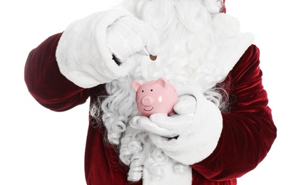 Photo of Santa Claus putting coin into piggy bank on white background, closeup
