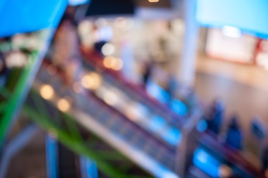 Blurred view of modern shopping mall interior with escalator