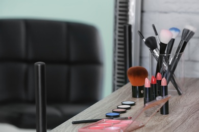 Photo of Decorative cosmetics and tools on dressing table in makeup room, closeup