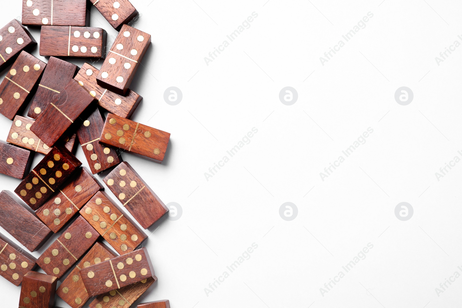 Photo of Wooden domino tiles on white background, flat lay. Space for text