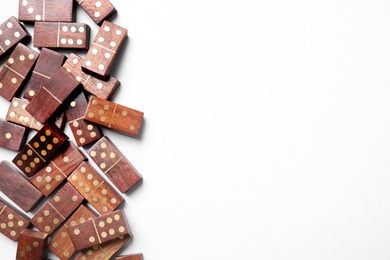 Photo of Wooden domino tiles on white background, flat lay. Space for text