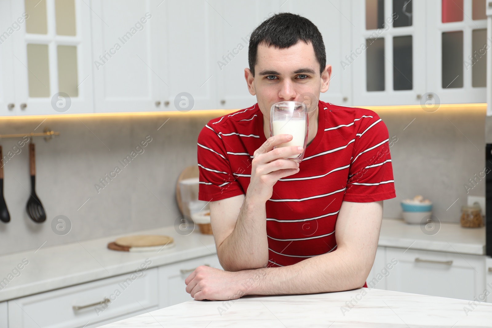 Photo of Milk mustache left after dairy product. Man drinking milk in kitchen