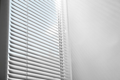 Photo of Window with closed horizontal blinds indoors, low angle view. Space for text