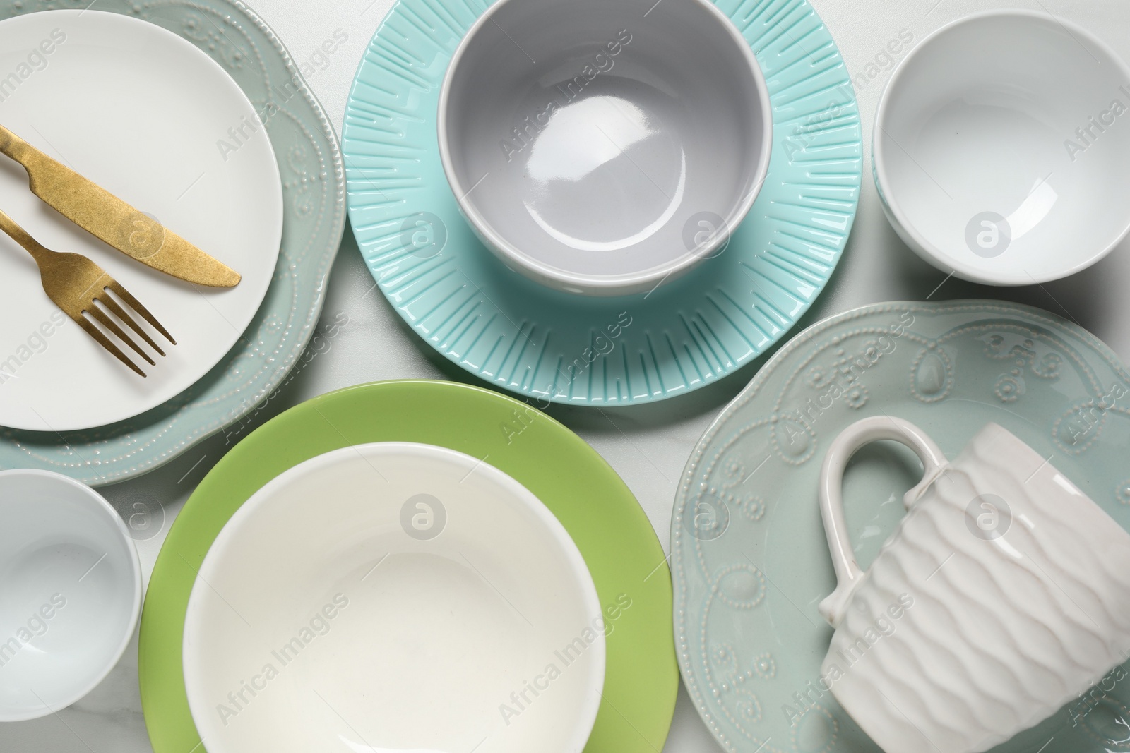 Photo of Beautiful ceramic dishware, cup and cutlery on white table, flat lay