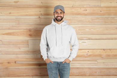 Portrait of young man in sweater at wooden wall. Mock up for design