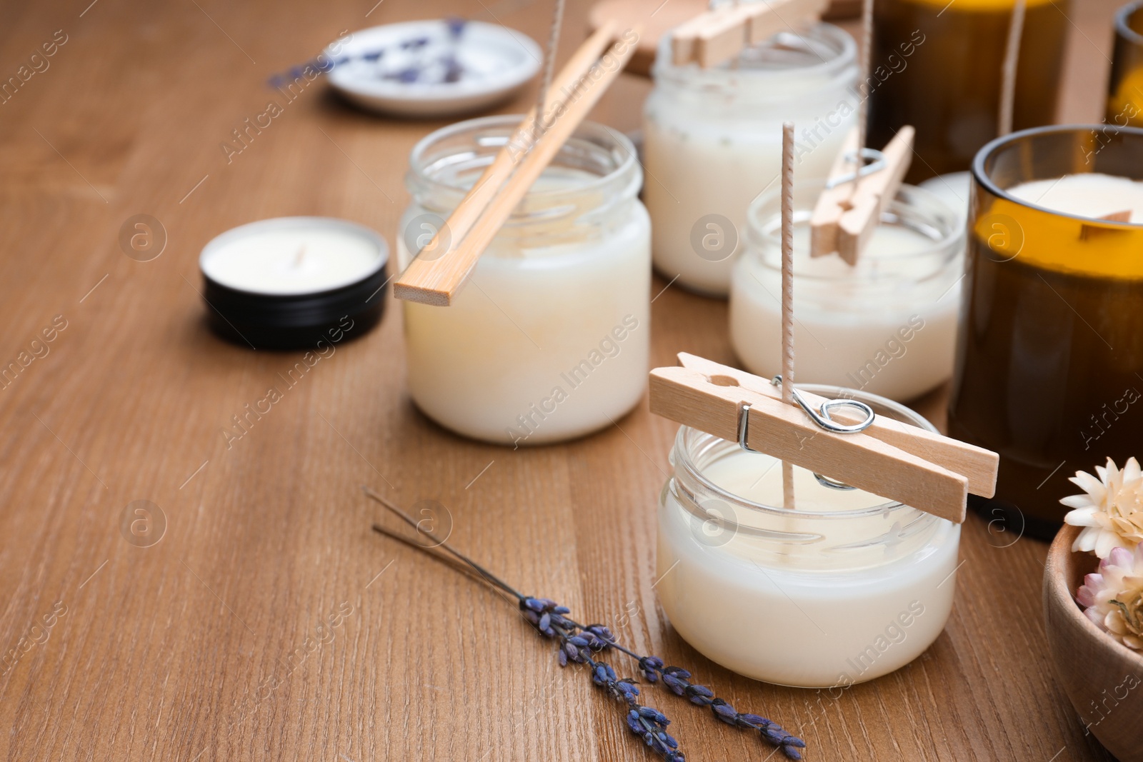 Photo of Glass jars with wax on wooden table, space for text. Handmade candles