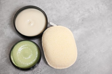 Photo of Natural body scrub, cream and sponge on grey table, above view. Space for text