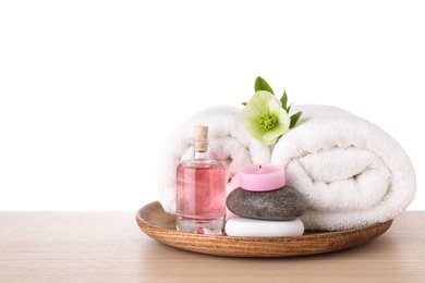 Photo of Tray with spa supplies on wooden table against white background