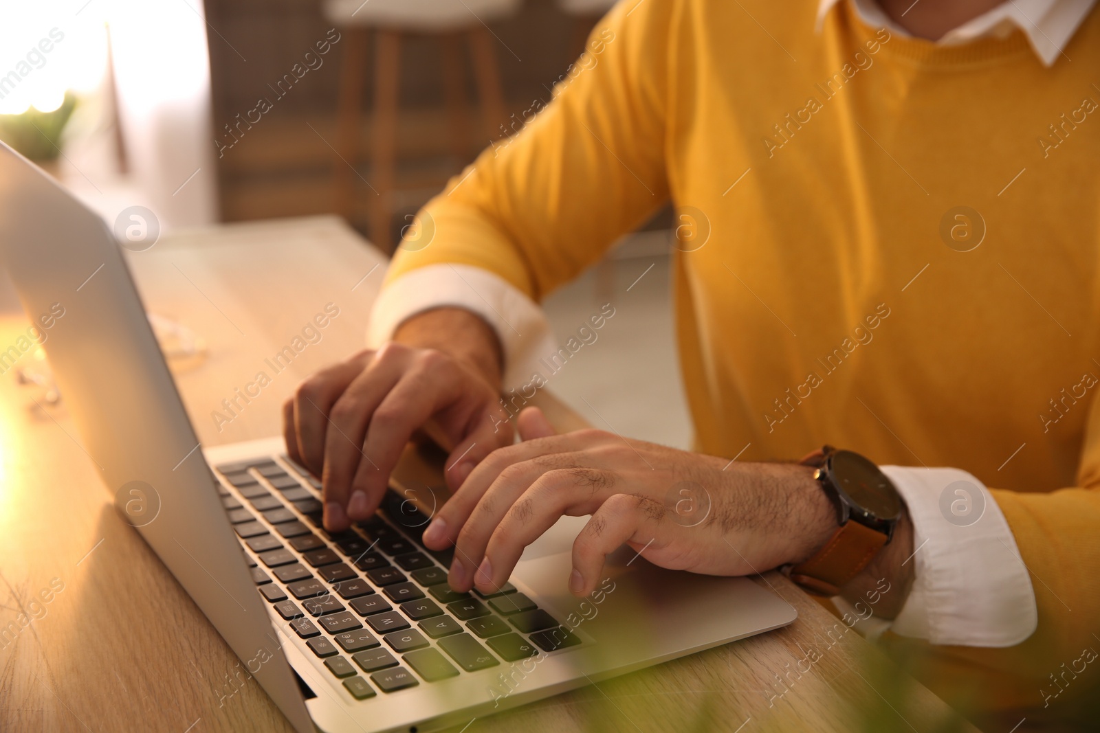 Photo of Man working with laptop at table in cafe, closeup