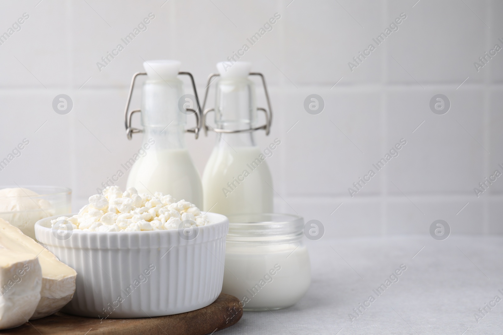 Photo of Different fresh dairy products on light table. Space for text