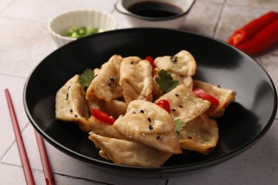 Photo of Delicious gyoza (asian dumplings) in bowl on table