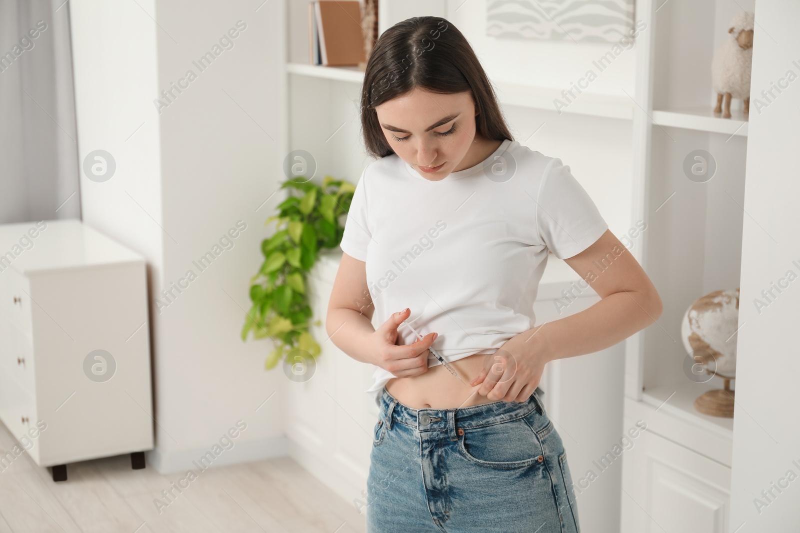 Photo of Diabetes. Woman making insulin injection into her belly at home