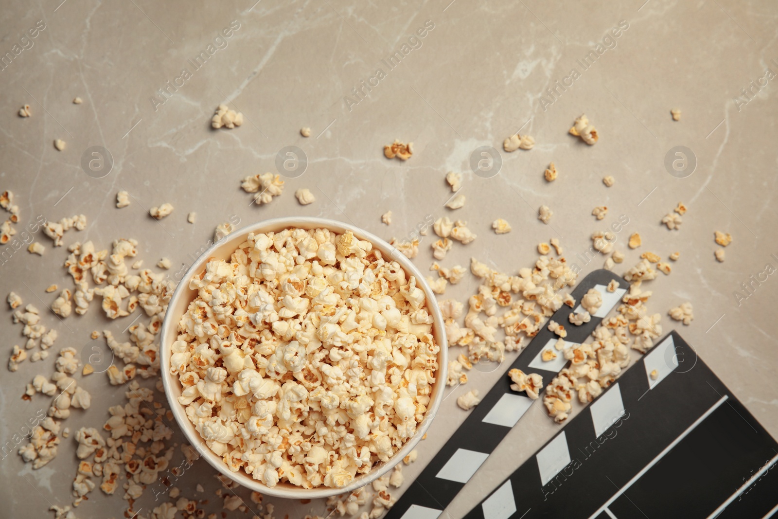 Photo of Flat lay composition with popcorn and clapperboard on grey background