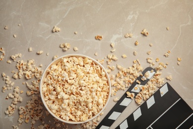 Flat lay composition with popcorn and clapperboard on grey background