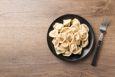 Tasty dumplings on wooden table, flat lay. Space for text