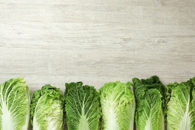 Fresh ripe Chinese cabbages on white wooden table, flat lay. Space for text