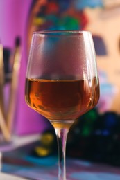 Photo of Glass of tasty wine on colorful background, closeup